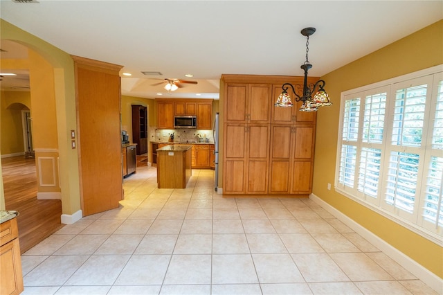 1550 Kevin Ln, Deland, FL 32724 - kitchen with stainless steel appliances, arched walkways, ceiling fan, brown cabinetry, and recessed lighting