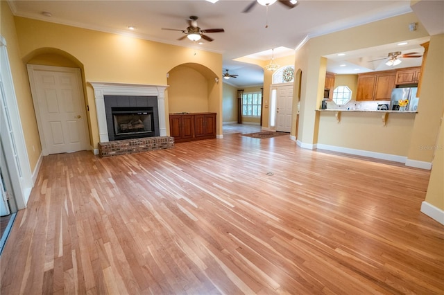 1550 Kevin Ln, Deland, FL 32724 - unfurnished living room featuring ceiling fan, crown molding, light wood-style flooring, baseboards, and a glass covered fireplace
