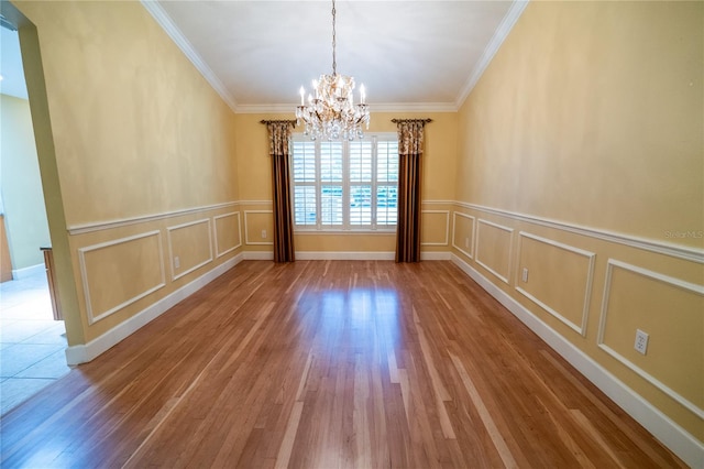 1550 Kevin Ln, Deland, FL 32724 - spare room featuring a chandelier, a decorative wall, wood finished floors, crown molding, and a wainscoted wall