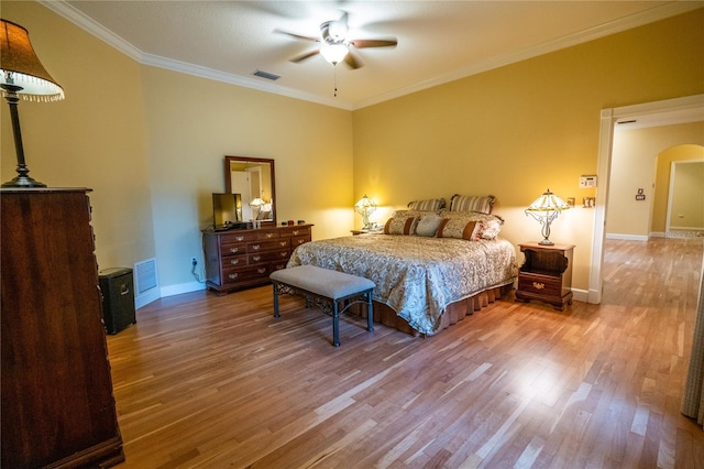 1550 Kevin Ln, Deland, FL 32724 - bedroom featuring wood finished floors, arched walkways, baseboards, and crown molding