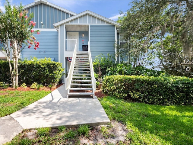 2533 Grassy Point Dr Unit 215, Lake Mary, FL 32746 - view of front facade with stairs, board and batten siding, a patio, and a front yard