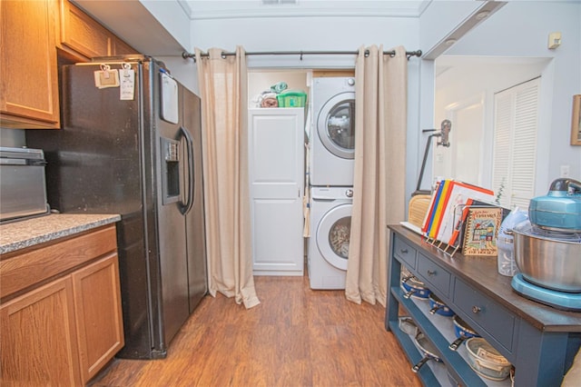 4545 Southfield Ave, Orlando, FL 32812 - laundry room featuring estacked washer and dryer and wood finished floors