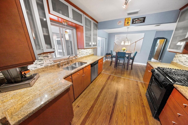 328 E Minnehaha Ave, Clermont, FL 34711 - kitchen with a sink, black range with gas stovetop, dishwasher, tasteful backsplash, and hardwood / wood-style floors