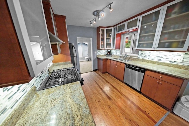 328 E Minnehaha Ave, Clermont, FL 34711 - kitchen featuring appliances with stainless steel finishes, a sink, exhaust hood, decorative backsplash, and light wood-style floors