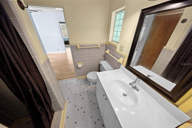 328 E Minnehaha Ave, Clermont, FL 34711 - bathroom with tile walls, toilet, tile patterned floors, vanity, and wainscoting