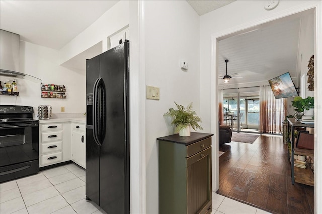 1126 Villa Ln Unit 91, Apopka, FL 32712 - kitchen with black appliances, wall chimney range hood, light tile patterned floors, white cabinets, and a ceiling fan