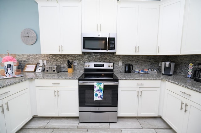 9014 Stinger Dr, Davenport, FL 33896 - kitchen with appliances with stainless steel finishes, light tile patterned floors, decorative backsplash, and white cabinetry