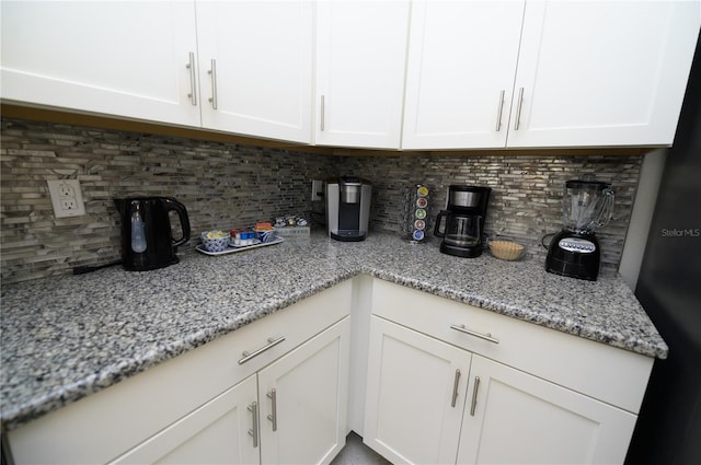 9014 Stinger Dr, Davenport, FL 33896 - kitchen with decorative backsplash, white cabinetry, and light stone counters
