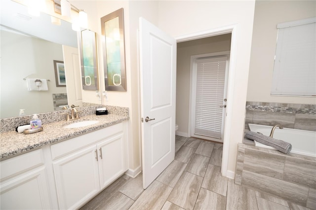 9014 Stinger Dr, Davenport, FL 33896 - full bath with vanity, a garden tub, and wood finish floors