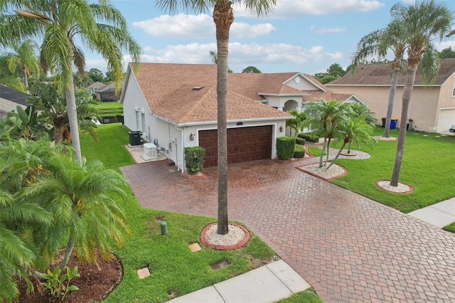 970 Sabal Grove Dr, Rockledge, FL 32955 - mediterranean / spanish-style home with stucco siding, central AC unit, roof with shingles, decorative driveway, and a garage