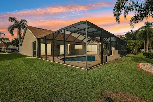 970 Sabal Grove Dr, Rockledge, FL 32955 - back of property at dusk featuring a yard, stucco siding, an outdoor pool, and a patio area
