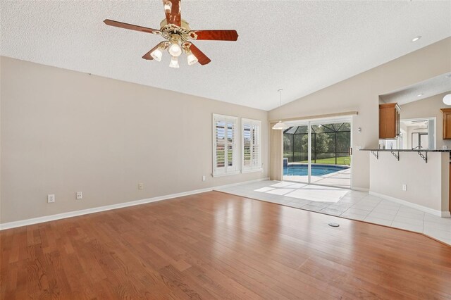 970 Sabal Grove Dr, Rockledge, FL 32955 - unfurnished room featuring vaulted ceiling, a textured ceiling, light wood-style flooring, ceiling fan, and baseboards