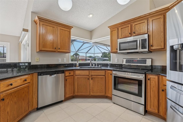 970 Sabal Grove Dr, Rockledge, FL 32955 - kitchen with stainless steel appliances, lofted ceiling, brown cabinetry, a sink, and a textured ceiling