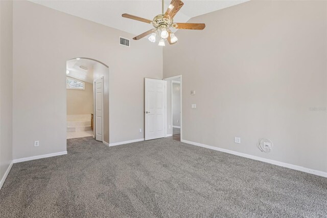 970 Sabal Grove Dr, Rockledge, FL 32955 - unfurnished bedroom featuring arched walkways, carpet flooring, baseboards, high vaulted ceiling, and ensuite bath
