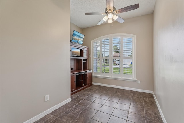 970 Sabal Grove Dr, Rockledge, FL 32955 - spare room with ceiling fan, baseboards, dark tile patterned flooring, and a textured ceiling