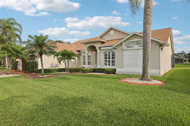 970 Sabal Grove Dr, Rockledge, FL 32955 - mediterranean / spanish-style home featuring stucco siding, a front lawn, and a shingled roof