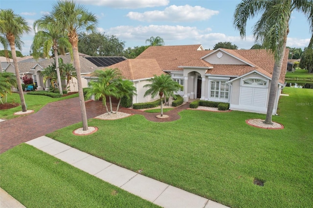 970 Sabal Grove Dr, Rockledge, FL 32955 - mediterranean / spanish-style home with stucco siding, decorative driveway, a front yard, and roof with shingles