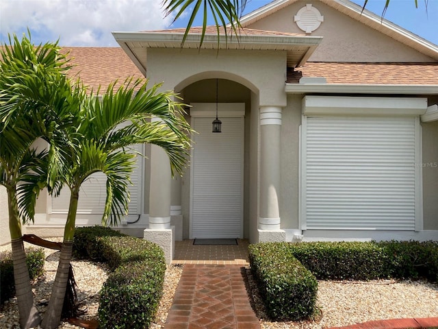 970 Sabal Grove Dr, Rockledge, FL 32955 - entrance to property with stucco siding, a shingled roof, and a garage