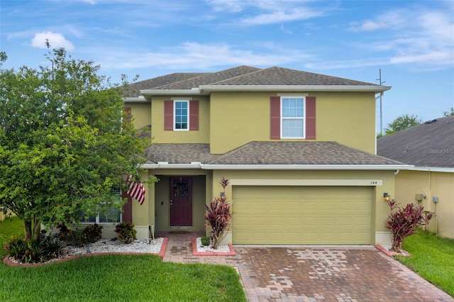 144 Williamson Dr, Davenport, FL 33897 - traditional-style house with stucco siding, decorative driveway, a shingled roof, and a front yard