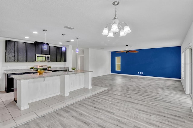 144 Williamson Dr, Davenport, FL 33897 - kitchen with appliances with stainless steel finishes, light wood-style flooring, a large island with sink, recessed lighting, and a ceiling fan