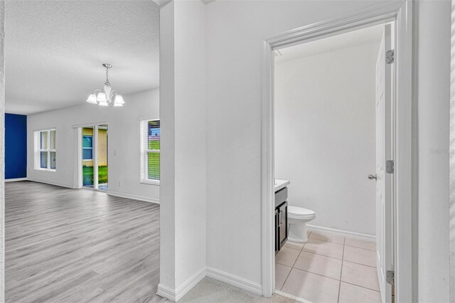 144 Williamson Dr, Davenport, FL 33897 - bathroom featuring vanity, a chandelier, baseboards, toilet, and a textured ceiling
