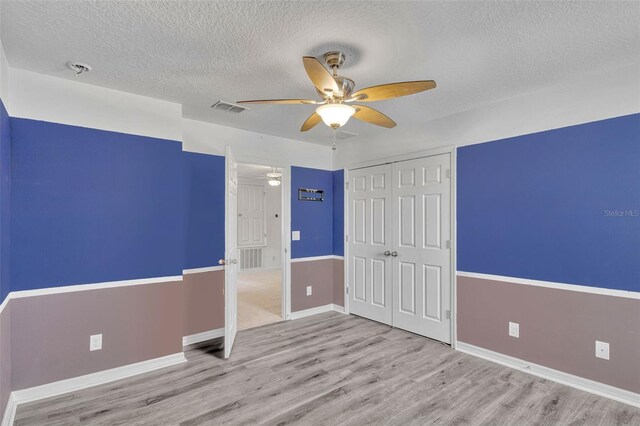 144 Williamson Dr, Davenport, FL 33897 - unfurnished bedroom with a textured ceiling, wood finished floors, a closet, and baseboards