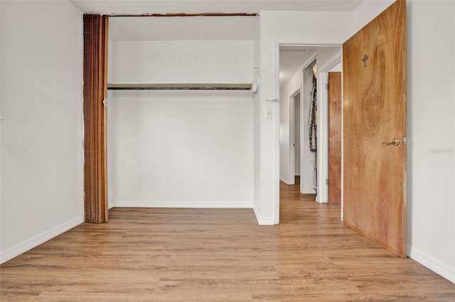 1170 E Bay St, Winter Garden, FL 34787 - unfurnished bedroom featuring a closet, light wood-type flooring, and baseboards