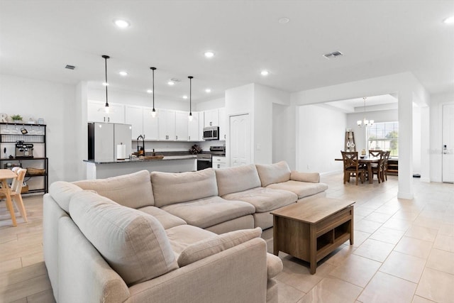 652 SW Mccoy Ave, Port St Lucie, FL 34953 - living room featuring recessed lighting, a chandelier, light tile patterned floors, and baseboards