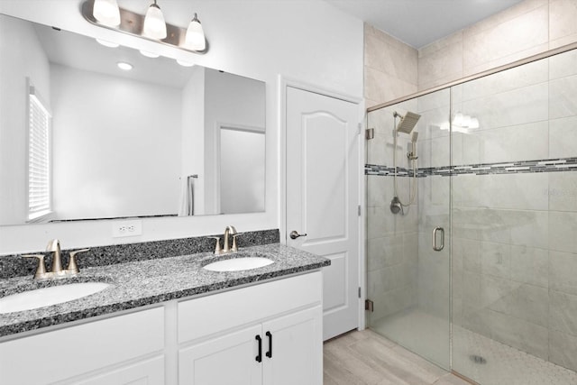 652 SW Mccoy Ave, Port St Lucie, FL 34953 - bathroom with a shower stall, double vanity, and wood finished floors