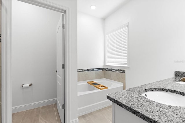 652 SW Mccoy Ave, Port St Lucie, FL 34953 - bathroom featuring a garden tub, double vanity, and tile patterned flooring