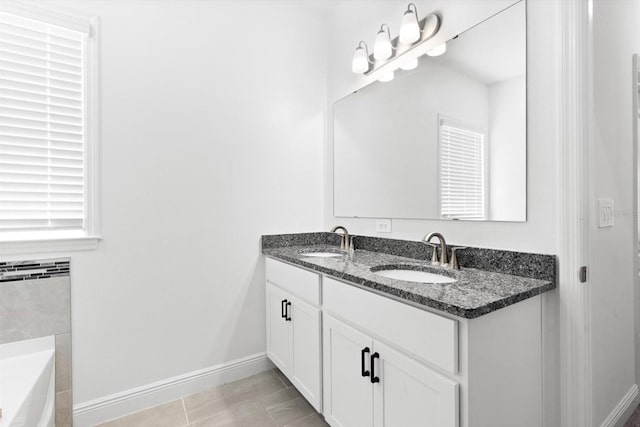 652 SW Mccoy Ave, Port St Lucie, FL 34953 - full bath featuring double vanity, baseboards, and a garden tub