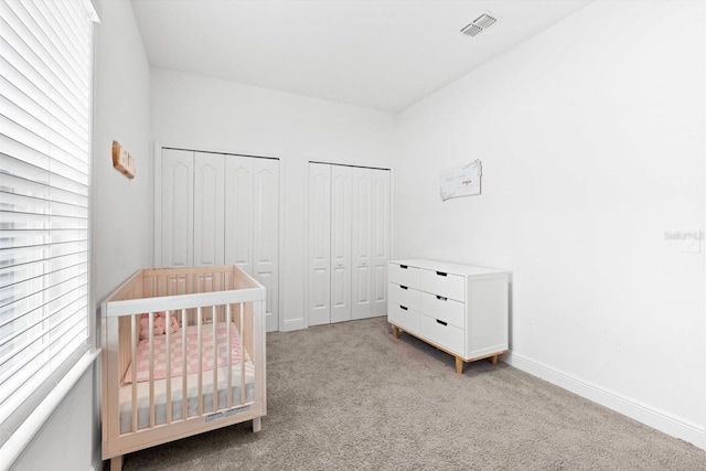652 SW Mccoy Ave, Port St Lucie, FL 34953 - bedroom featuring carpet flooring, multiple closets, baseboards, and a crib