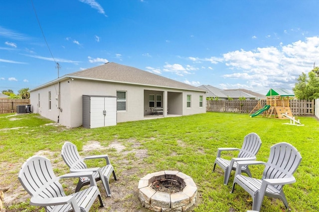 652 SW Mccoy Ave, Port St Lucie, FL 34953 - rear view of house with an outdoor fire pit, stucco siding, a patio, central AC, and a playground