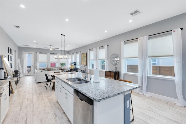 13334 Beebe Aly, Orlando, FL 32827 - kitchen featuring stainless steel dishwasher, a sink, light wood-style floors, ceiling fan, and a kitchen island with sink
