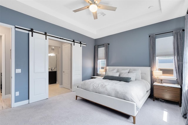 13334 Beebe Aly, Orlando, FL 32827 - bedroom with a barn door, light colored carpet, a tray ceiling, and ceiling fan