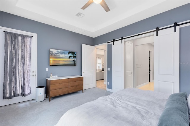 13334 Beebe Aly, Orlando, FL 32827 - bedroom featuring a barn door, light colored carpet, and ceiling fan