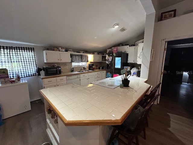 2847 Crk 756, Webster, FL 33597 - kitchen with tile counters, white appliances, a peninsula, dark wood-style floors, and white cabinets