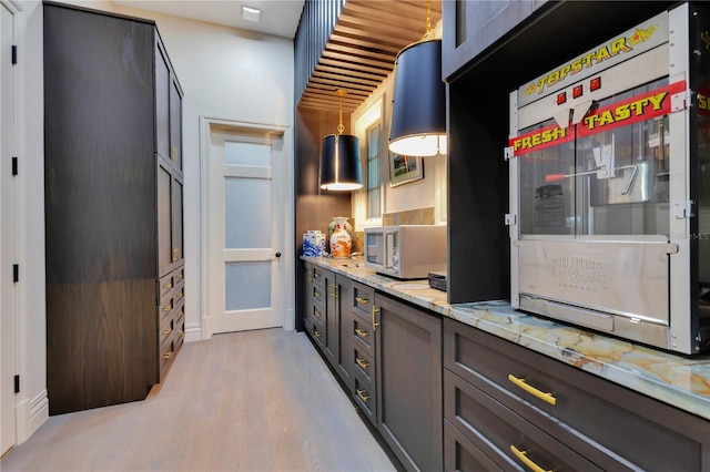 11103 Bridge House Rd, Windermere, FL 34786 - kitchen featuring light wood-style flooring and light stone counters