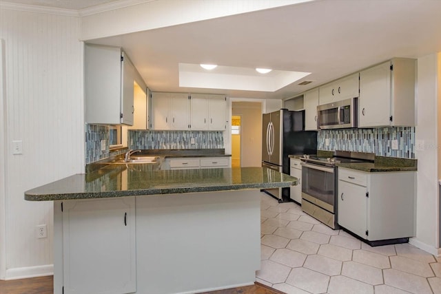 4739 Indian Gap Dr, Orlando, FL 32812 - kitchen featuring stainless steel appliances, backsplash, a tray ceiling, a peninsula, and ornamental molding