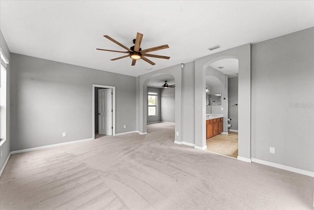 2753 Glenridge Cir, Merritt Island, FL 32953 - unfurnished living room with ceiling fan, arched walkways, light colored carpet, and baseboards