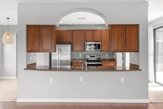 2753 Glenridge Cir, Merritt Island, FL 32953 - kitchen with appliances with stainless steel finishes, a peninsula, and brown cabinets