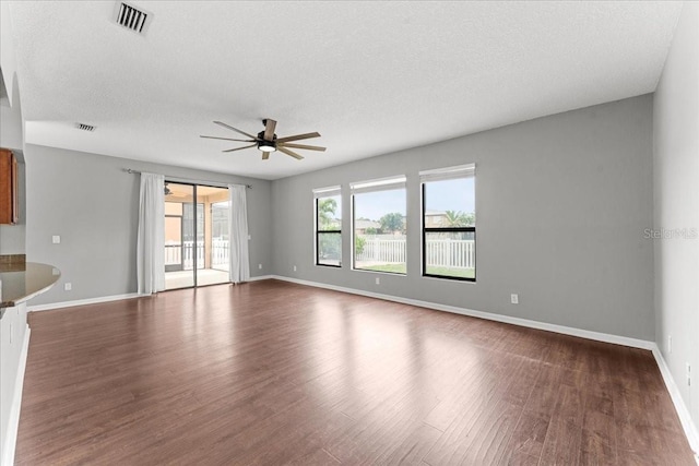 2753 Glenridge Cir, Merritt Island, FL 32953 - unfurnished living room featuring a ceiling fan, dark wood-type flooring, baseboards, and a textured ceiling