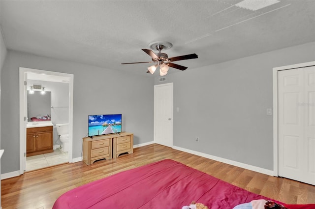 1940 S Conway Rd Unit 8, Orlando, FL 32812 - bedroom featuring light wood-type flooring, ensuite bath, a textured ceiling, and ceiling fan