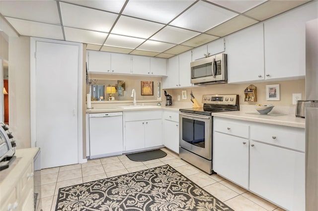 14 Escondido Ct Unit 134, Altamonte Springs, FL 32701 - kitchen featuring appliances with stainless steel finishes, a sink, a paneled ceiling, light countertops, and light tile patterned floors