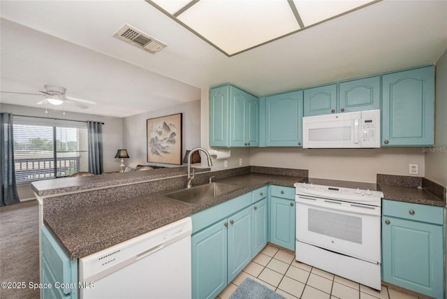 1515 Huntington Ln Unit 426, Rockledge, FL 32955 - kitchen featuring white appliances, a sink, dark countertops, a peninsula, and blue cabinets