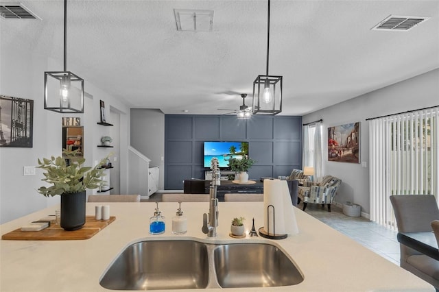 2620 Waterline St, Kissimmee, FL 34743 - kitchen with a sink, ceiling fan, a textured ceiling, light countertops, and tile patterned floors