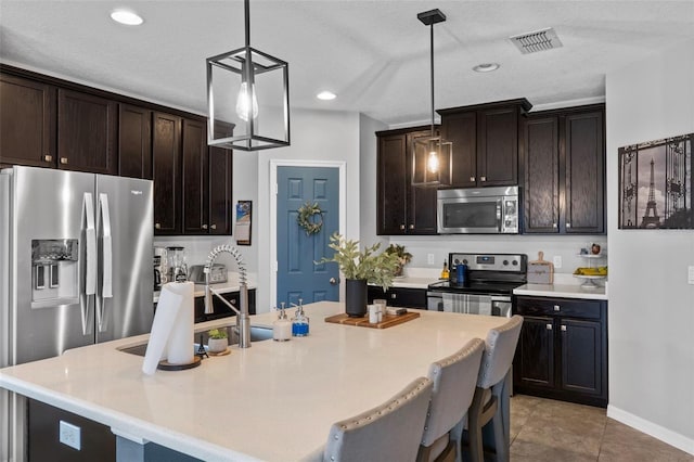 2620 Waterline St, Kissimmee, FL 34743 - kitchen featuring appliances with stainless steel finishes, dark brown cabinetry, decorative light fixtures, light countertops, and recessed lighting