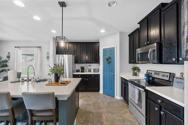 2620 Waterline St, Kissimmee, FL 34743 - kitchen featuring stainless steel appliances, a sink, light countertops, a textured ceiling, and pendant lighting