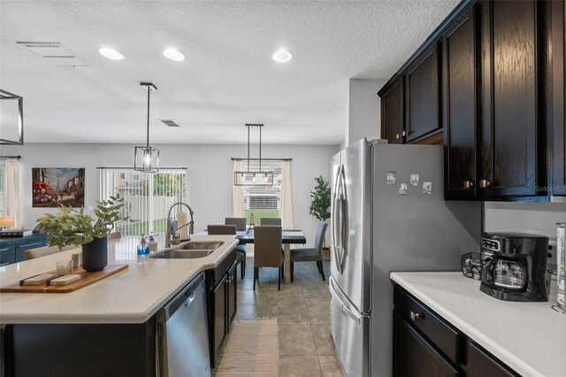 2620 Waterline St, Kissimmee, FL 34743 - kitchen featuring a sink, stainless steel appliances, light countertops, a kitchen island with sink, and light tile patterned floors
