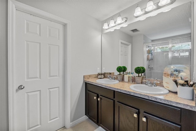 2620 Waterline St, Kissimmee, FL 34743 - bathroom with a shower stall, double vanity, tile patterned floors, and a textured ceiling